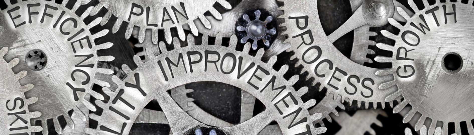 Meshed gears with words superimposed, including process, improvement, efficiency, plan, growth, skill, quality and goal 