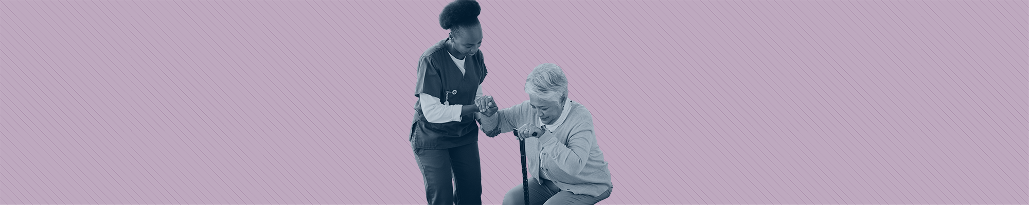 A care worker helps and elderly woman with a cane stand up.