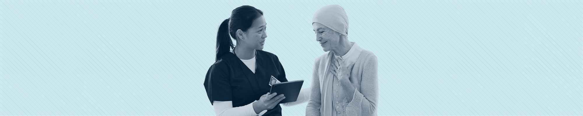 A health care provider shows cancer patient a clipboard. The patient touches her chest with relief.