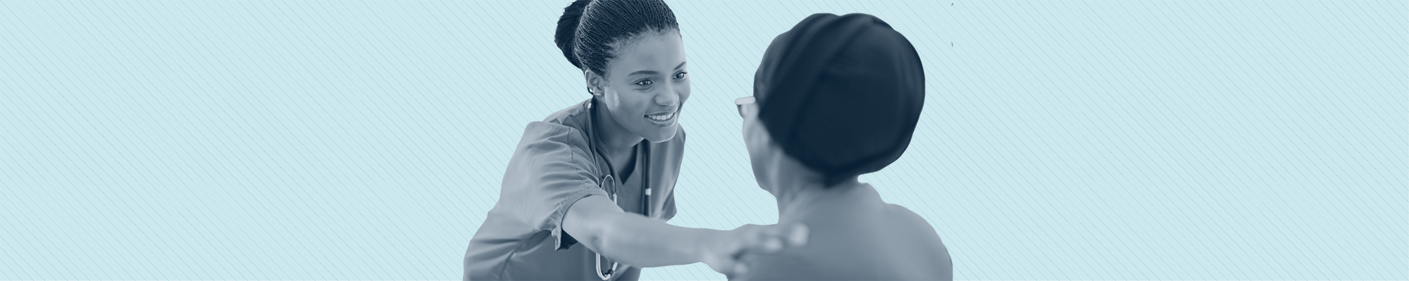 A health care provider warmly puts her hand on an elder woman's shoulder
