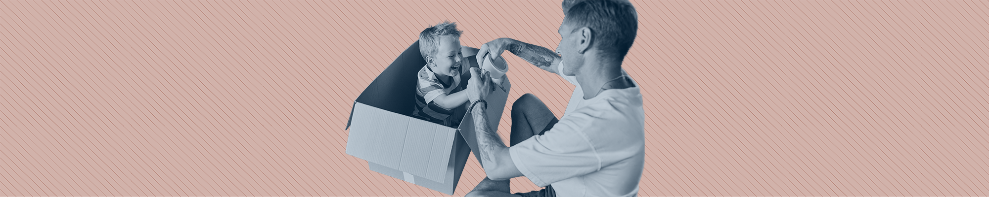 A man plays with his son, who is sitting in a moving box.